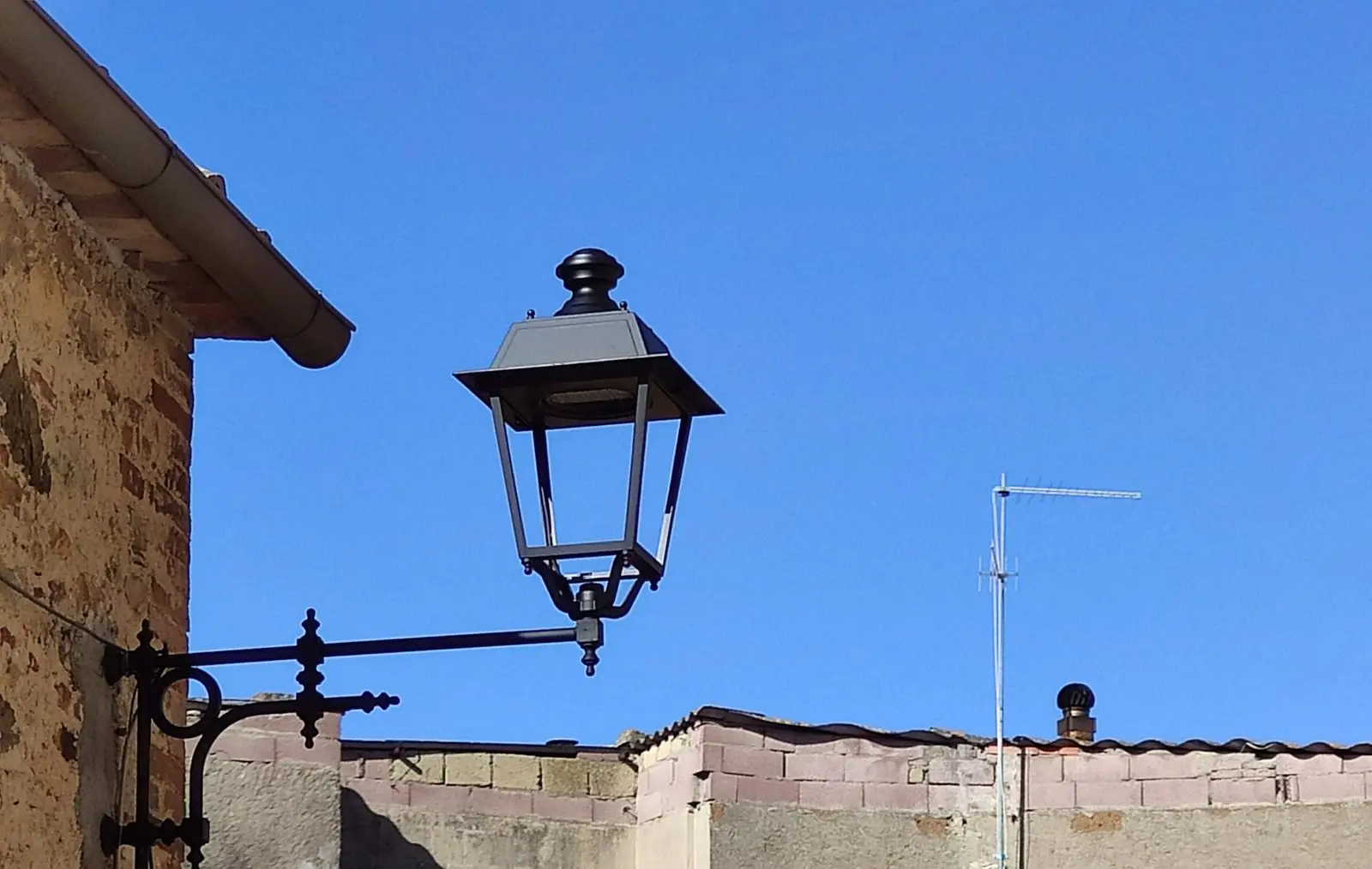 Lanterna classica su mensola a muro in ferro per l'illuminazione pubblica di un borgo storico