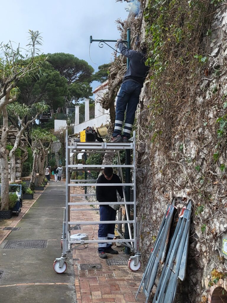 Durante i lavori: montaggio del braccio decorativo sul palo vintage a Capri