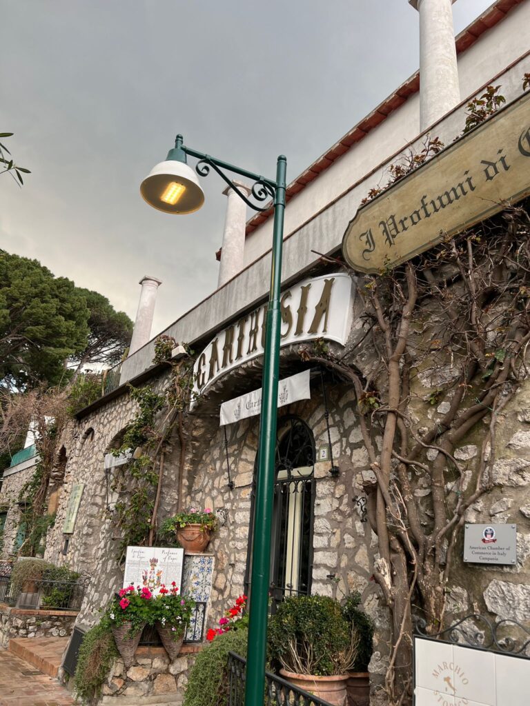 Palo vintage con braccio decorativo e lanterna Capri L300 accesa in Via Matteotti, Capri